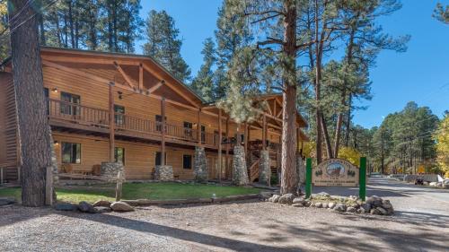 Upper Canyon Inn & Cabins في رويدوسو: كابينة خشبية كبيرة مع شرفة التفاف