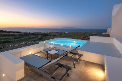 uma villa com piscina à noite em Aplada Suites em Oia