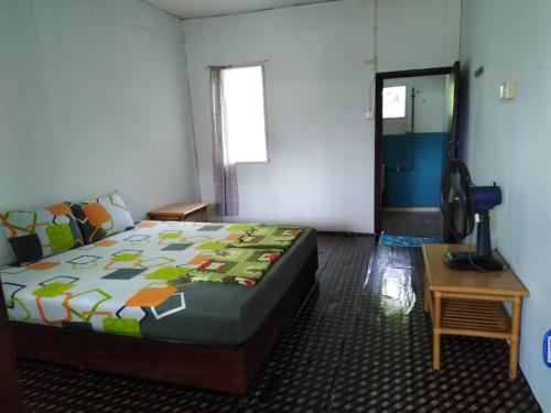 een slaapkamer met een bed, een tafel en een raam bij AA Homestay in Mulu