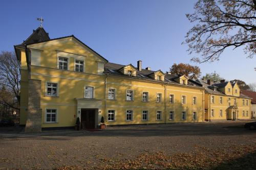 een groot geel gebouw met veel ramen bij Pałac Lucja BB in Zakrzów