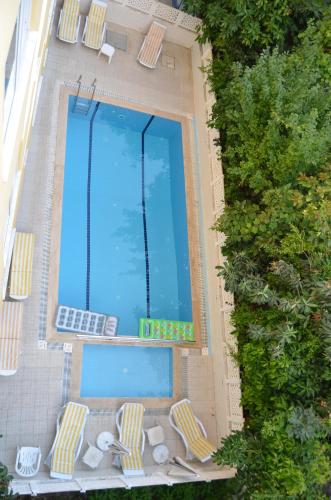 uma vista sobre uma piscina com espreguiçadeiras e uma piscina em Bayram Apart Hotel em Alanya