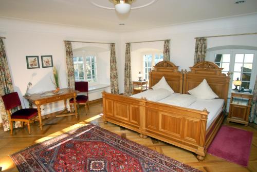 a bedroom with a large wooden bed and a desk at Hotel Gasthof Löwen in Vaduz