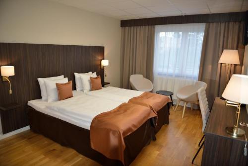 Cette chambre comprend un grand lit et une fenêtre. dans l'établissement Hotell Nova, à Karlstad