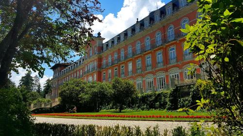 a large building with red flowers in front of it at Vidago Palace in Vidago