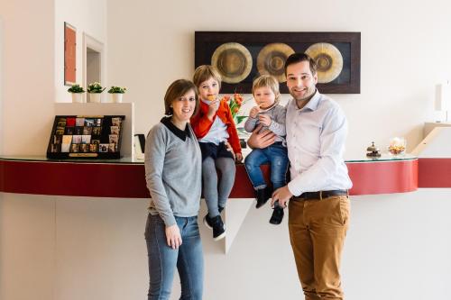 une famille debout devant un comptoir dans un magasin dans l'établissement Hotel Prado, à Ostende