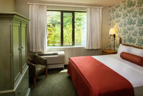 a hotel room with a bed and a window at Williamsburg Woodlands Hotel & Suites, an official Colonial Williamsburg Hotel in Williamsburg