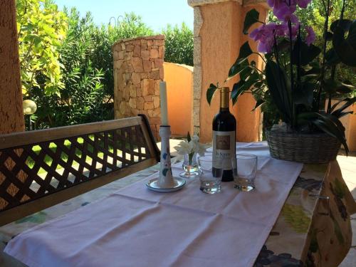 una mesa con una botella de vino y una vela en Villa Oleandro - 2349447, en San Teodoro