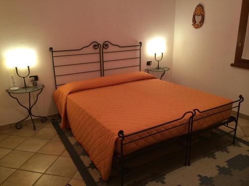 1 dormitorio con 1 cama grande de color naranja y 2 mesas en Villa Oleandro - 2349447, en San Teodoro