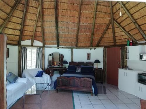 una camera con letto e divano di Clarens socialites, Thatch Cottage #1 a Bethlehem