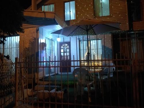 una casa con una mesa y una sombrilla por la noche en Alojamiento en Chillán en Chillán