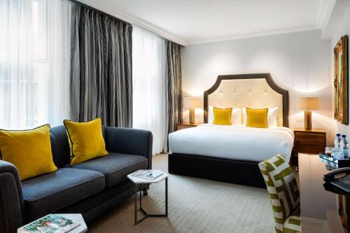 a hotel room with a bed and a couch at Radisson Blu Hotel, London South Kensington - formerly Vanderbilt in London