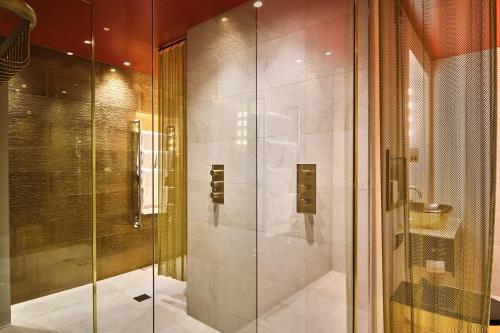 y baño con ducha y puerta de cristal. en Megaro Hotel en Londres