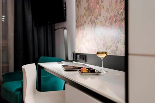 a glass of wine on a white counter in a room at Boutique Hotel Atrium München in Munich