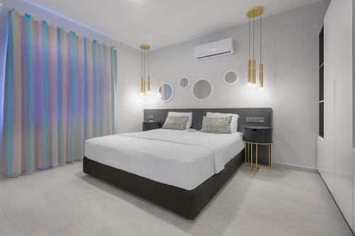 1 dormitorio con cama blanca y cortina colorida en Twin Apart Hotel, en Alanya