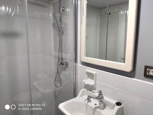 La salle de bains est pourvue d'un lavabo et d'une douche avec un miroir. dans l'établissement loft el taller, à Lumpiaque