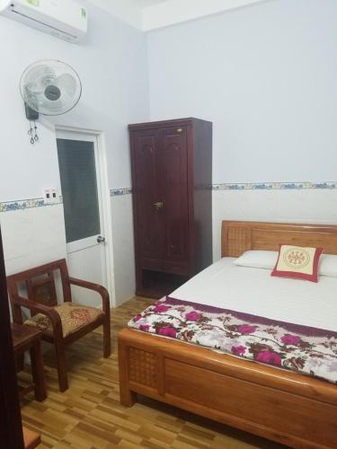 um quarto com uma cama, uma cadeira e uma ventoinha em MyDungmotel em Da Nang