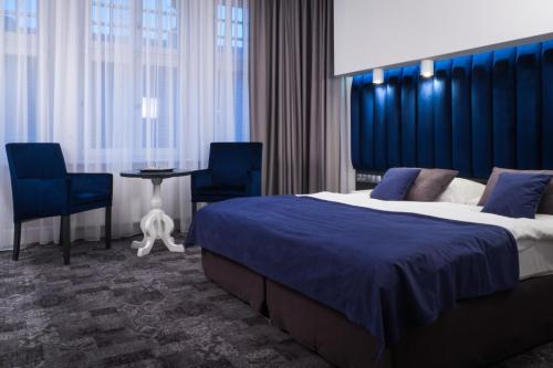 een hotelkamer met een bed en een tafel en stoelen bij City Boutique Hotel in Zielona Góra