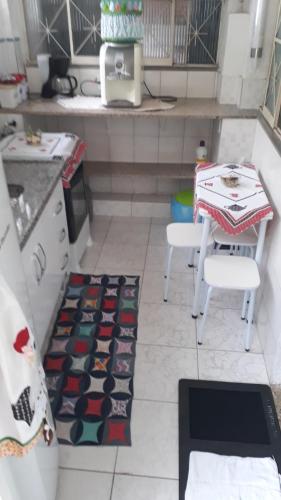 cocina con mesa, 2 sillas y alfombra en Pertinho da Mata en Cachoeiras de Macacu