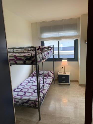 um quarto com 2 beliches e um candeeiro em Apartamento en Residencia SB L'Ampolla em L'Ampolla