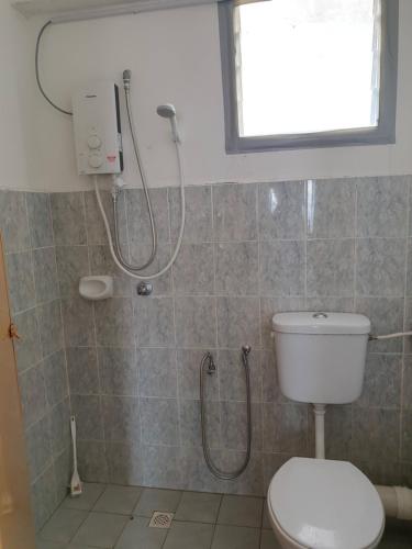 La salle de bains est pourvue d'une douche et de toilettes. dans l'établissement Kinora Homestay, à Perai