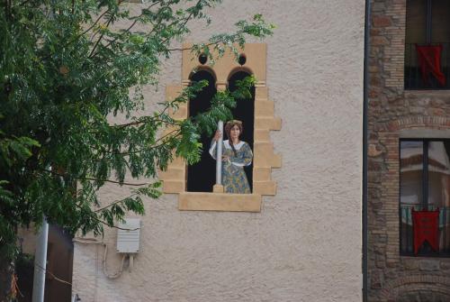 a woman is looking out of a window at La Casa Del Miracle in Balaguer