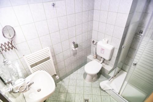 La salle de bains blanche est pourvue de toilettes et d'un lavabo. dans l'établissement 4 Évszak Hegyihotel, à Mátraháza