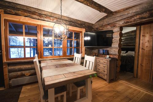 uma sala de jantar com uma mesa de madeira e uma televisão em Kelokolo, Ivalo em Ivalo