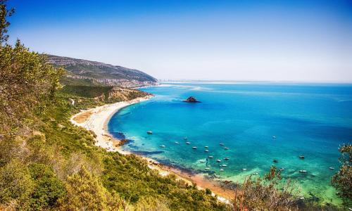 - une vue sur une plage avec des bateaux dans l'eau dans l'établissement Hotel Cristal Setúbal, à Setúbal