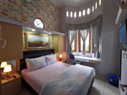 - une chambre avec un grand lit et 2 fenêtres dans l'établissement Nariska Suite Homestay, à Yogyakarta