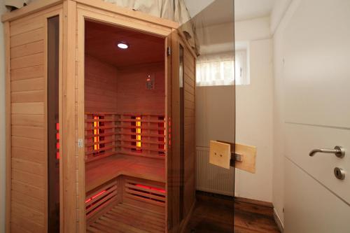 uma sauna com uma porta de madeira num quarto em Chalet Sabrina mit Außenpool im Sommer em Kaprun