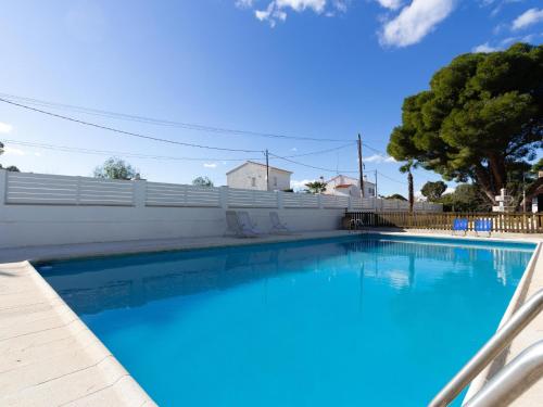 una gran piscina azul con una valla blanca en INNOUTHOME A estrenar gran casa y piscina torrente, en L'Ametlla de Mar