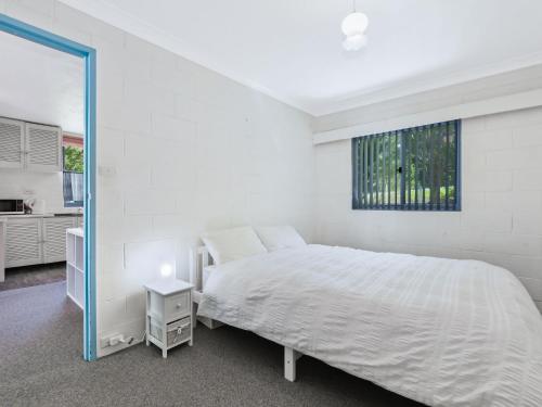 a white bedroom with a bed and a window at Blueys Beach Villa Manyana 11 in Blueys Beach