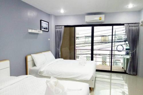 1 Schlafzimmer mit 2 Betten und einem großen Fenster in der Unterkunft Khoksametchun Hostel Plus in Hat Yai