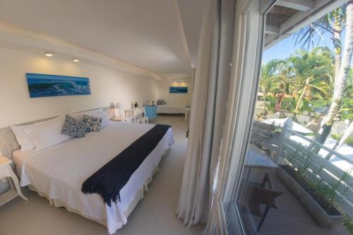 1 dormitorio con cama y ventana grande en Auberge de la Langouste en Búzios