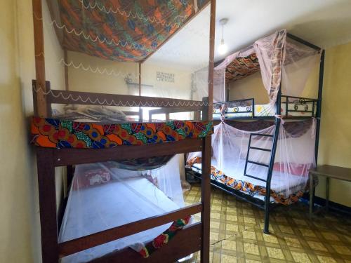 Un pat sau paturi într-o cameră la First Point Arusha Hostel