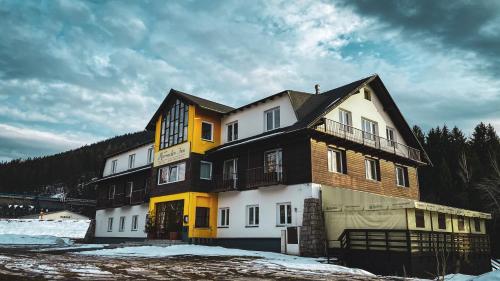 una casa grande se muestra en la nieve en Hotel Harrachov Inn, en Harrachov