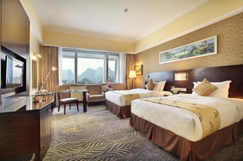 เตียงในห้องที่ Lijiang Waterfall Hotel Guilin