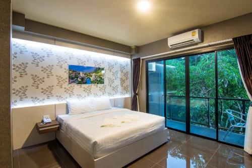 - une chambre avec un lit et une grande fenêtre dans l'établissement PSG Hotel, à Udon Thani