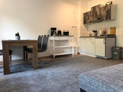 Zimmer mit einem Tisch und einer Küche mit einer Theke in der Unterkunft Viadrina Rooms & Apartments Frankfurt-Oder am Park im Zentrum in Frankfurt (Oder)