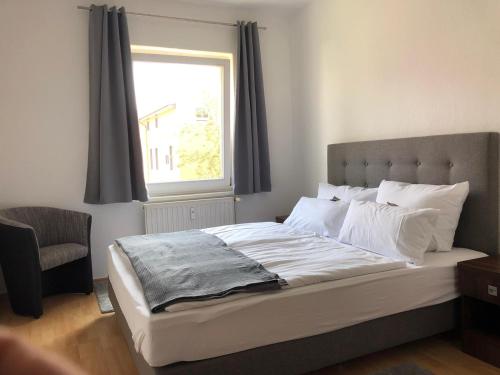 Schlafzimmer mit einem großen Bett und einem Fenster in der Unterkunft Viadrina Rooms & Apartments Frankfurt-Oder am Park im Zentrum in Frankfurt (Oder)