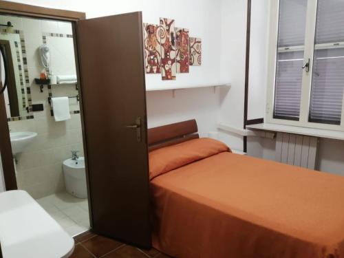 una piccola camera con letto e bagno di Albergo Ollolai a Civitavecchia