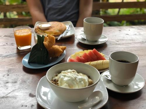 un tavolo con due tazze di caffè e una ciotola di cibo di Lanta Para hut a Ko Lanta