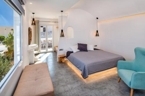 een slaapkamer met een bed en een blauwe stoel bij Gianna Suites in Fira