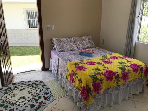 1 dormitorio con 1 cama con edredón de flores en Pousada Mera en Florianópolis