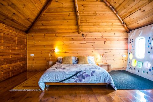 een slaapkamer met een bed in een houten hut bij Casa Inspirada in Los Estancos