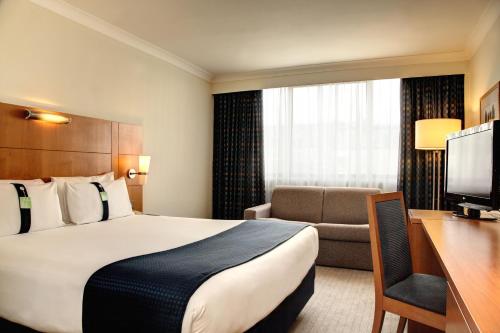 ein Hotelzimmer mit einem Bett und einem Schreibtisch in der Unterkunft Holiday Inn London Bloomsbury, an IHG Hotel in London