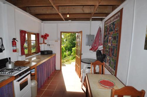 uma cozinha com uma mesa e um fogão forno superior em Castara Villas em Castara