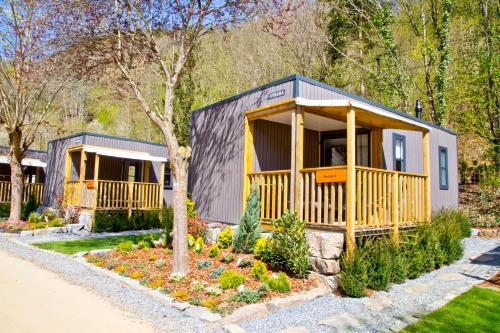 una casa pequeña con un gran porche en un jardín en Chalet Fuusslee en Goebelsmuhle