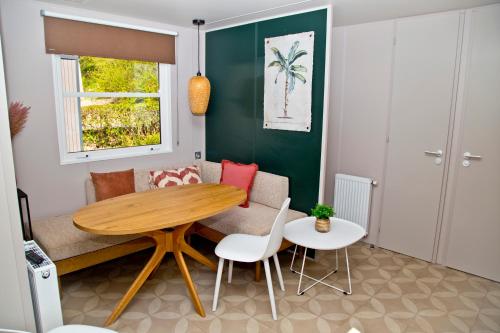 sala de estar con mesa de madera y sillas en Chalet Fuusslee en Goebelsmuhle