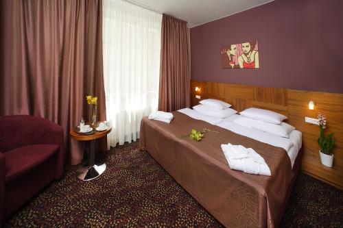 una camera d'albergo con letto e sedia di 1.Republic Hotel a Praga